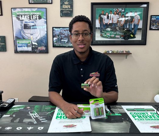 store associate holding a carbon monoxide detector battery